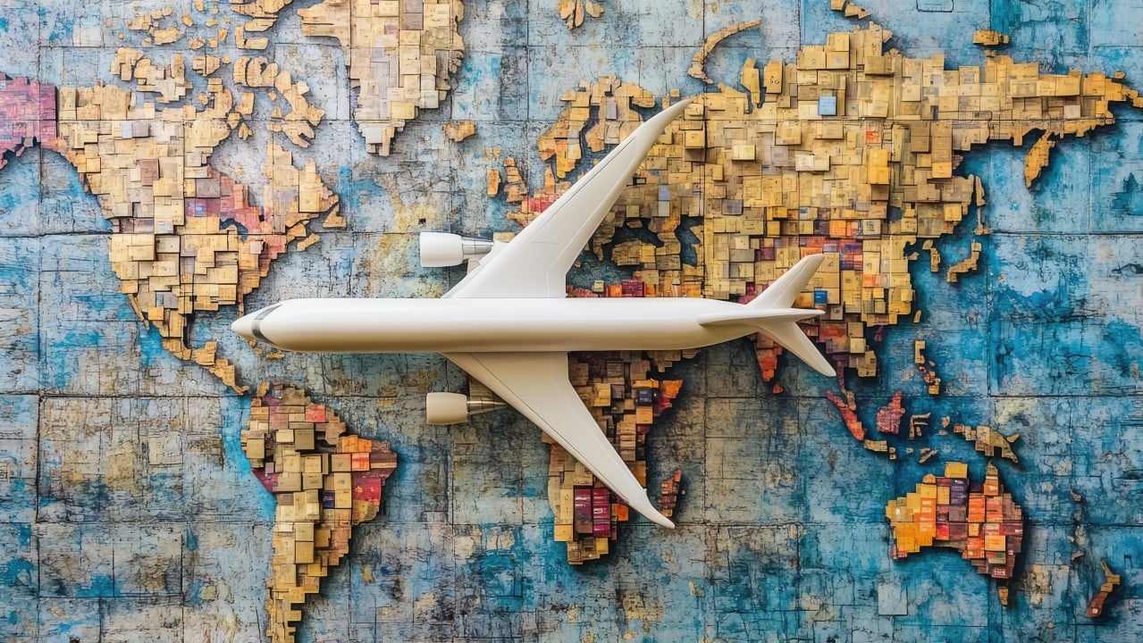 White airplane over a world map By Syarifuddin [Adobe Stock Photos]