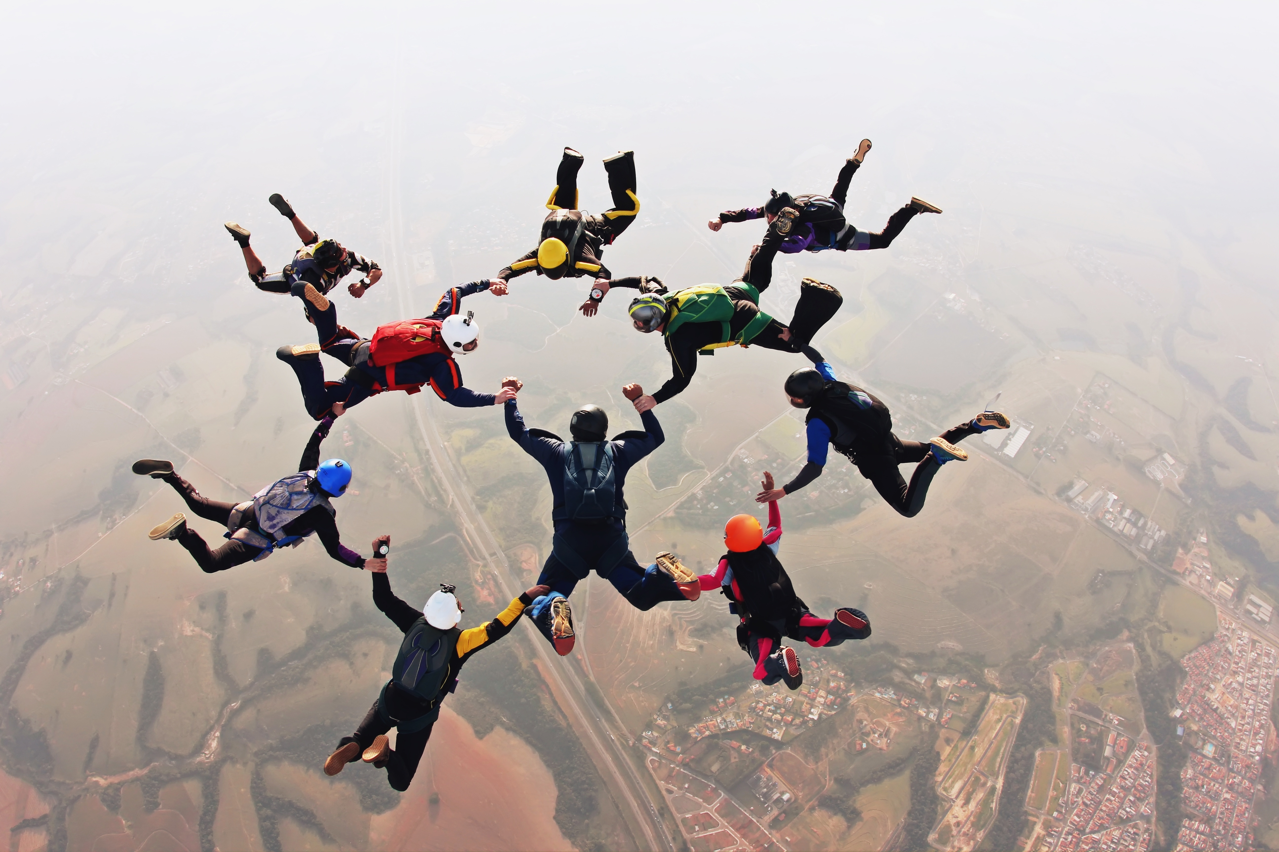 Skydivers holding hands making a fomation. High angle view. By Mauricio G