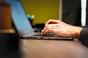 hands typing on a laptop