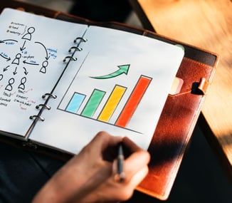 hand drawing a growth chart in a notebook