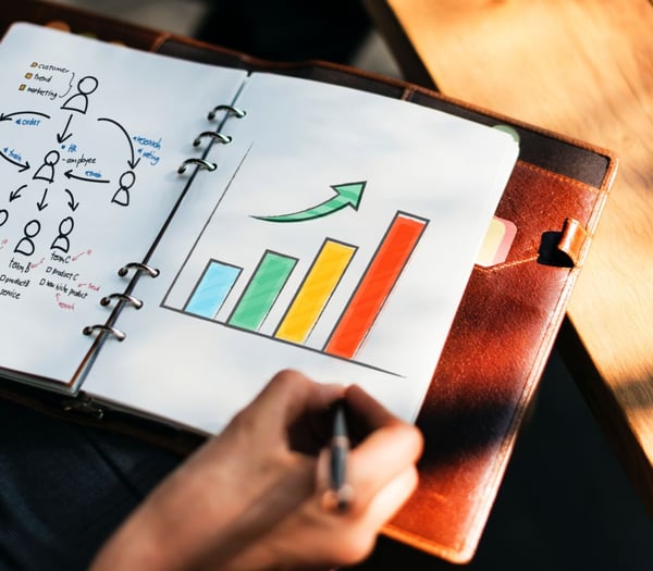 hand drawing a growth chart in a notebook