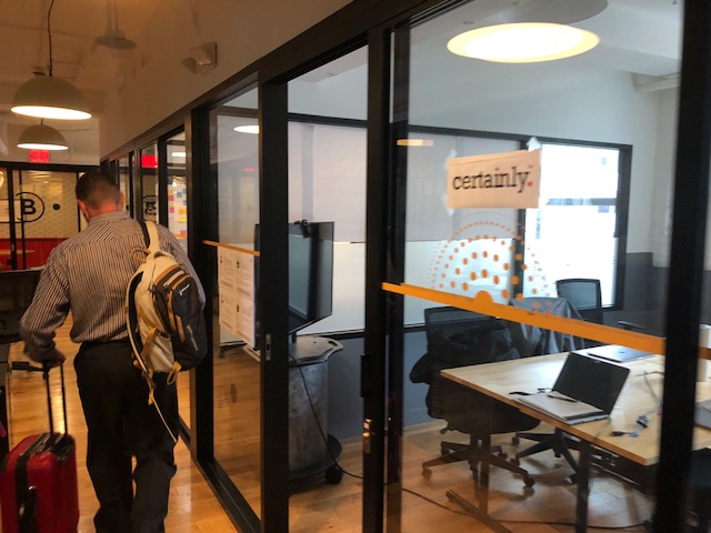 man leaving the office with a suitcase and backpack