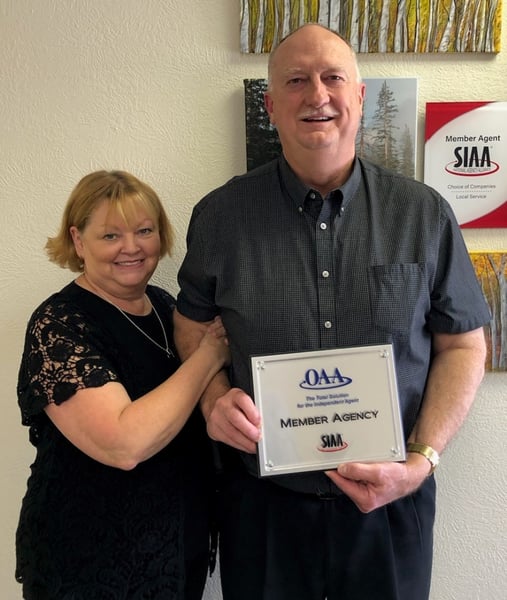 man and woman holding a member agency award