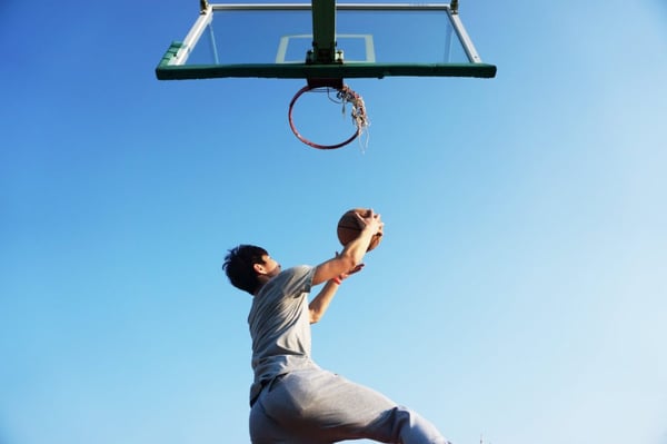 guy under a basketball hoop with a ball, about to throw it in