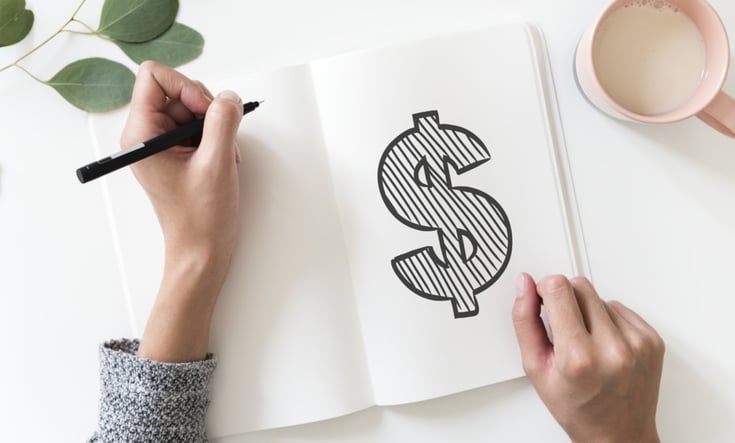 person drawing a dollar sign in a sketch book 